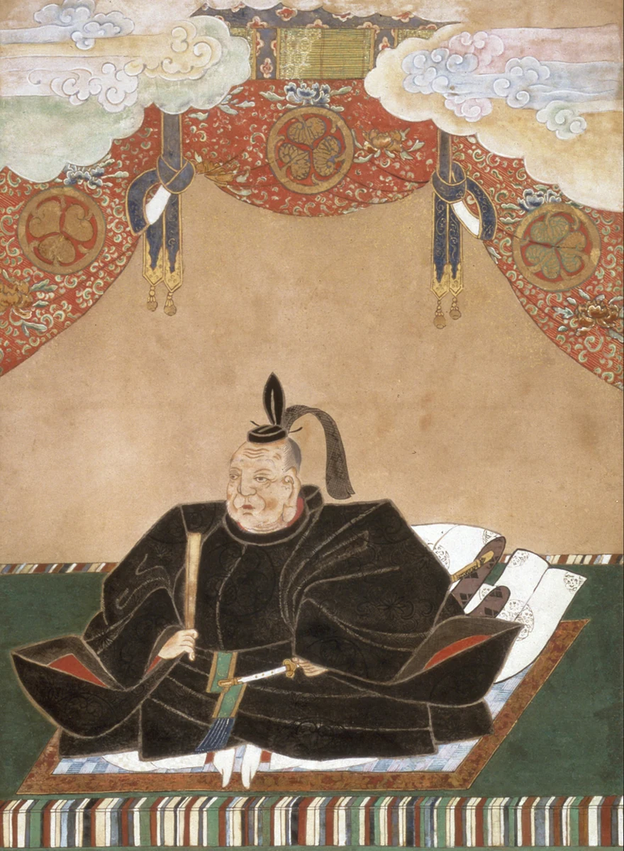 Ieyasu in dark ceremonial robes beneath an ornate canopy in a painted image of him as a deity.