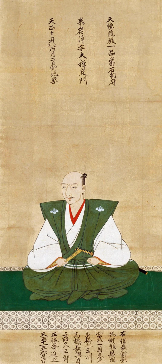 Nobunaga sits in formal robes, with memorial inscriptions above and below his portrait.