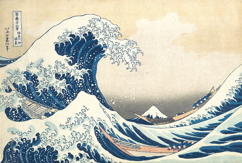A great curling wave towers above long low boats; a small snow-topped Mount Fuji appears beyond the water near the centre-right.