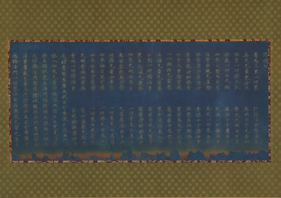 Silver characters run in columns over deep blue paper. Its uneven scorched lower edge survives inside a later patterned mounting.